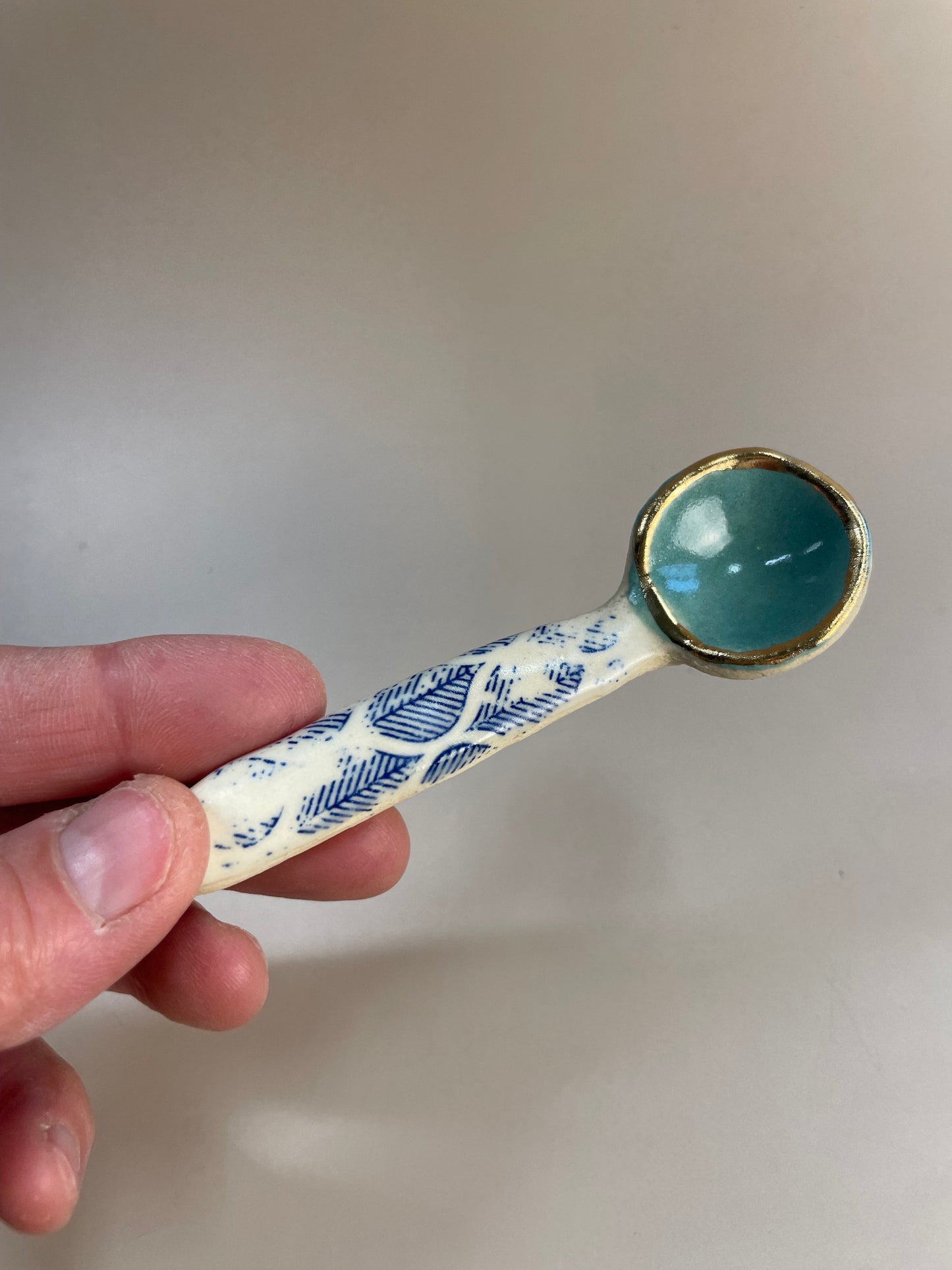 Handmade ceramic aqua and blue leaf spoon with gold luster rim.