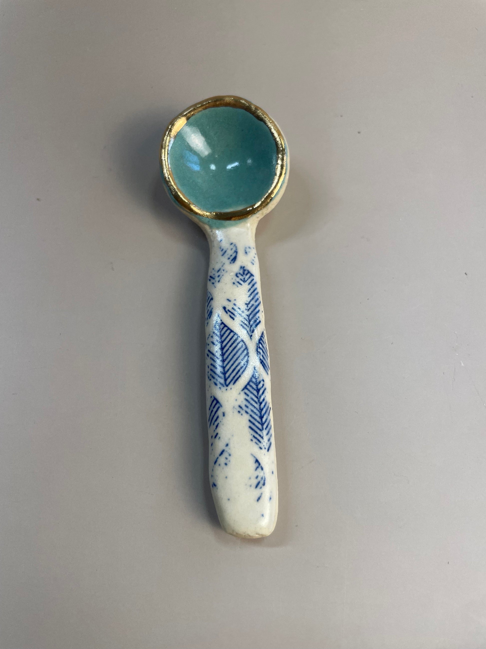 Handmade ceramic aqua and blue leaf spoon with gold luster rim.