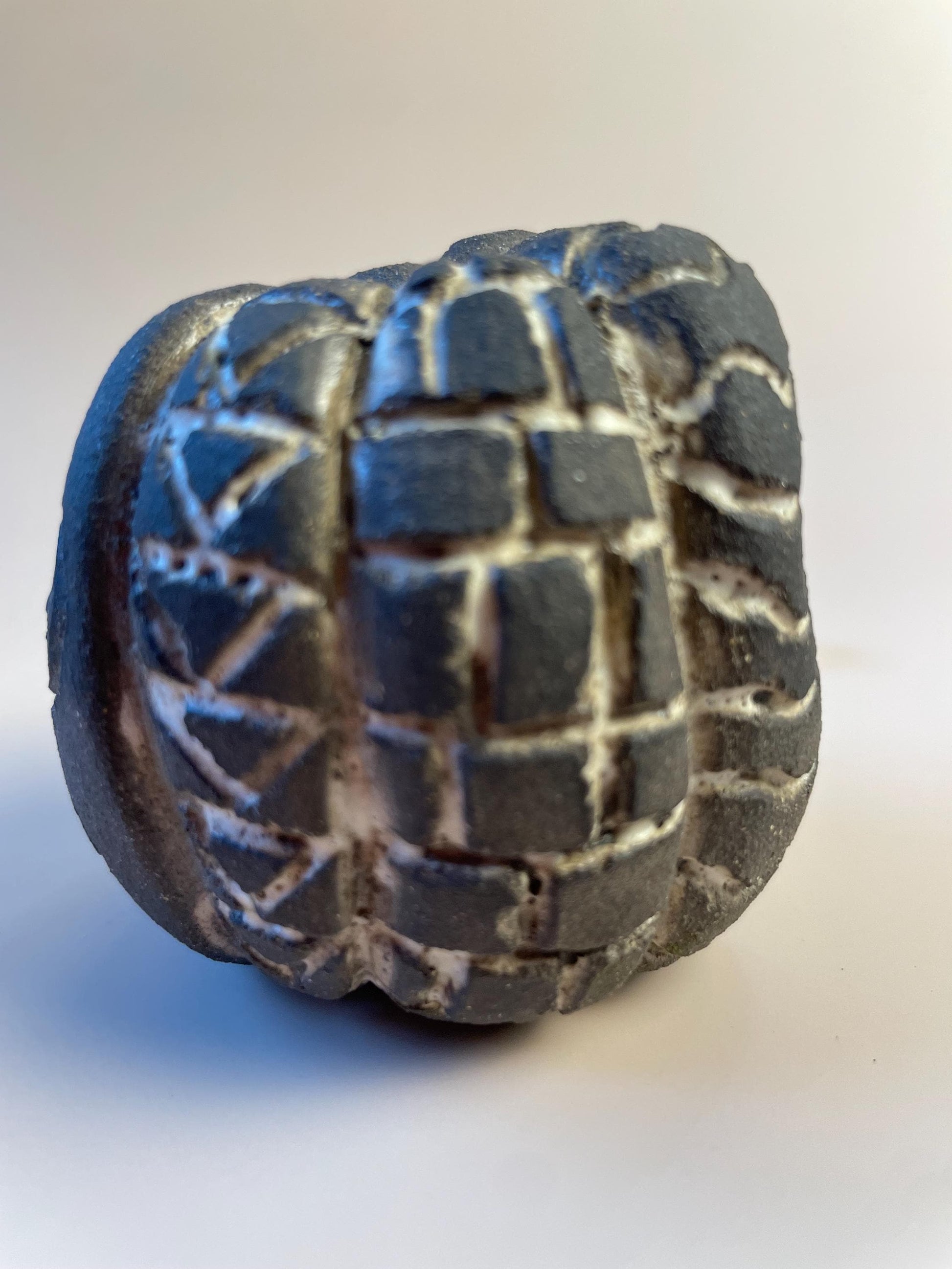 Handmade ceramic carved clay rattle with spiral and eye symbols