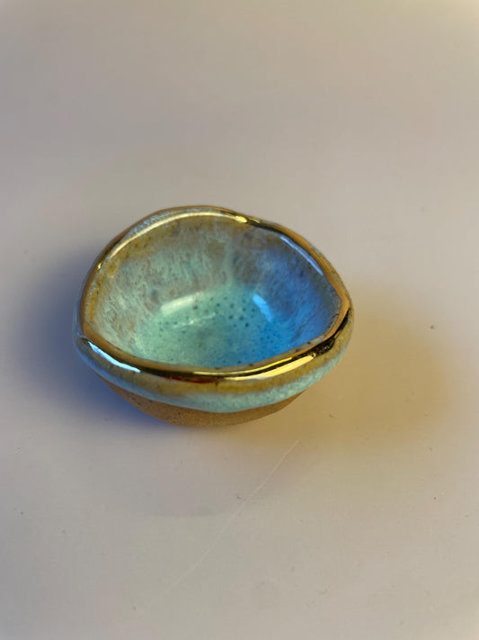 Tiny pinched ceramic bowl in aqua with gold rim