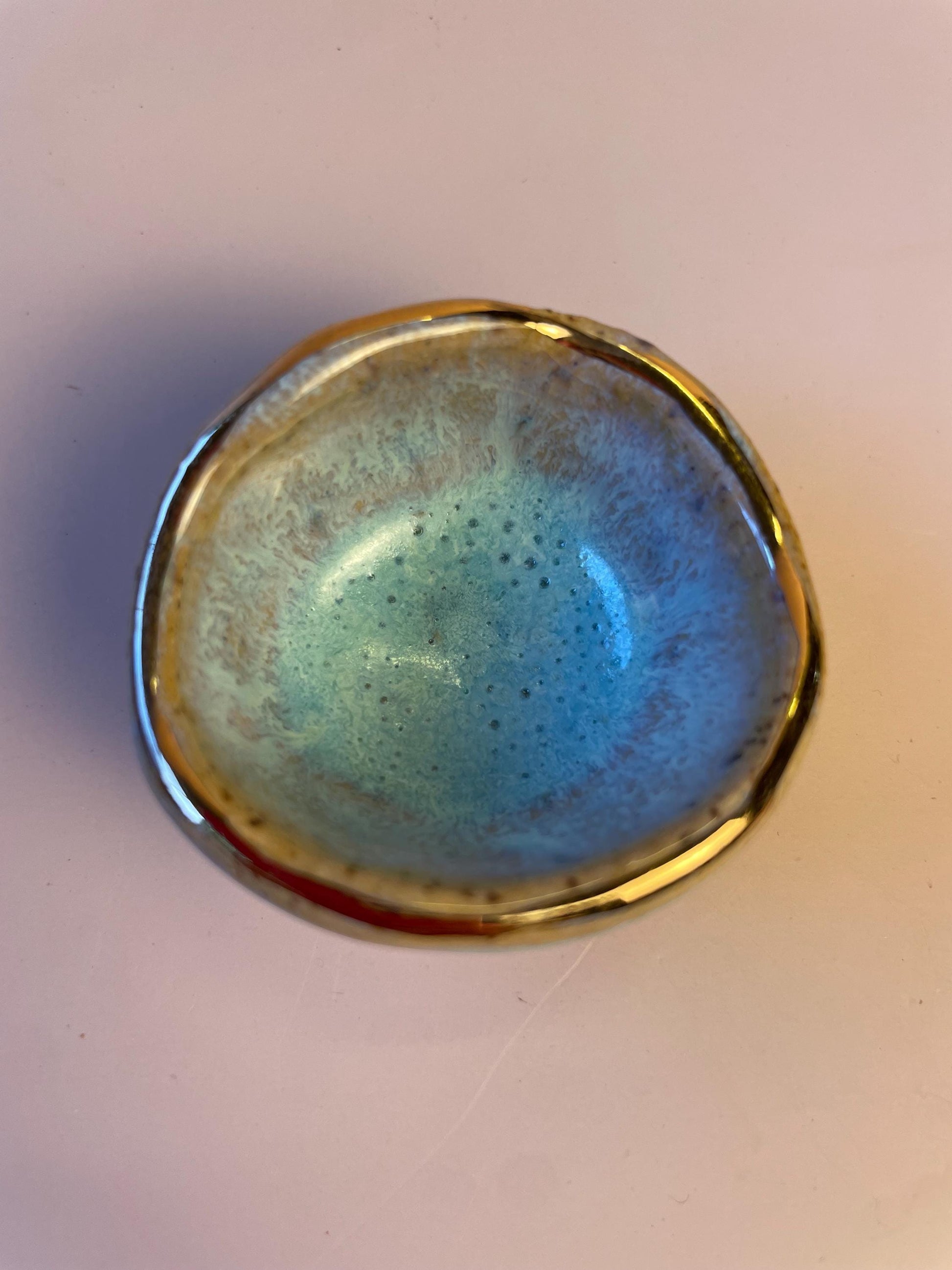Tiny pinched ceramic bowl in aqua with gold rim