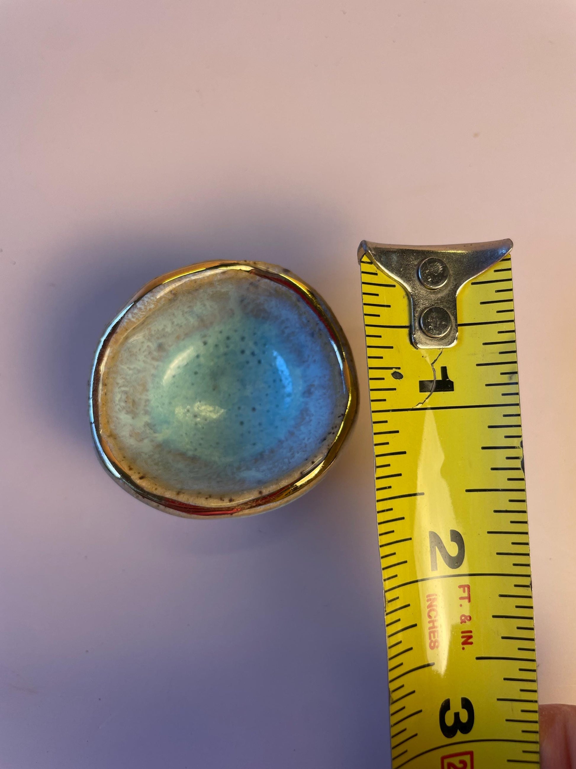 Tiny pinched ceramic bowl in aqua with gold rim