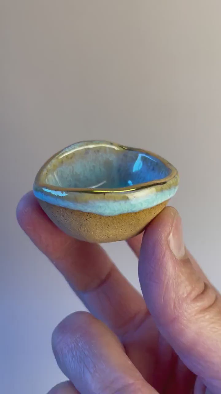 Tiny pinched ceramic bowl in aqua with gold rim
